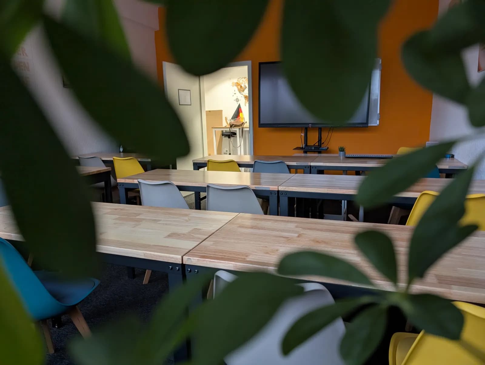 Deutschkurs im Unterrichtsraum mit Tischen und Whiteboard